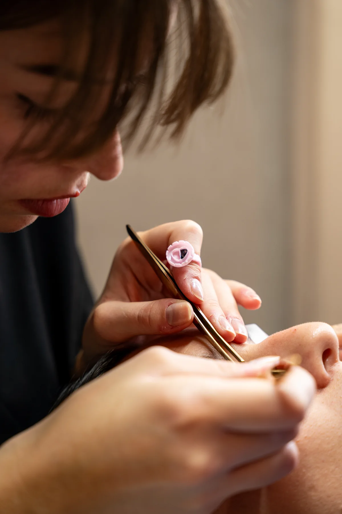 Léa réalise une pose de cils dans son institut de Cesson-Sévigné